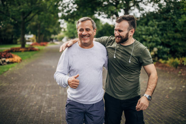 istock Man and son exercising in park together 1192265091