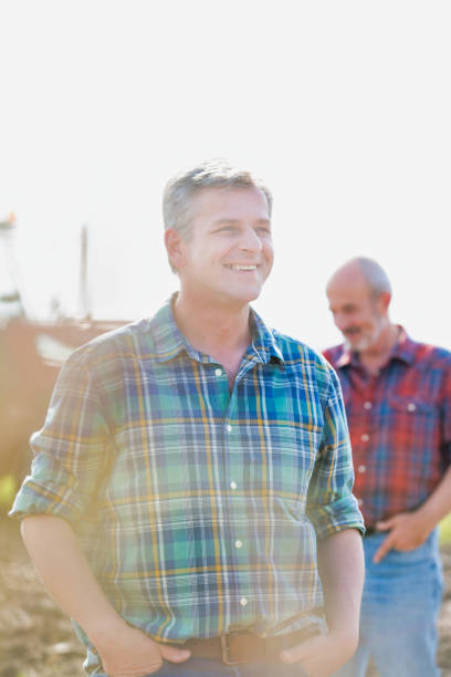 istock Smiling mature farmer standing in field 1192265919