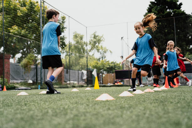 istock Determined girls and boys practicing soccer drills on field 1192266034