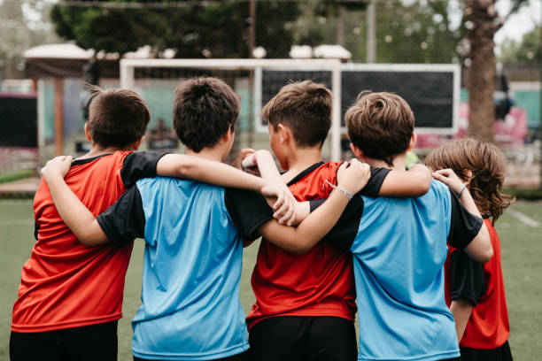 istock Boys standing arm around on soccer field 1192266051