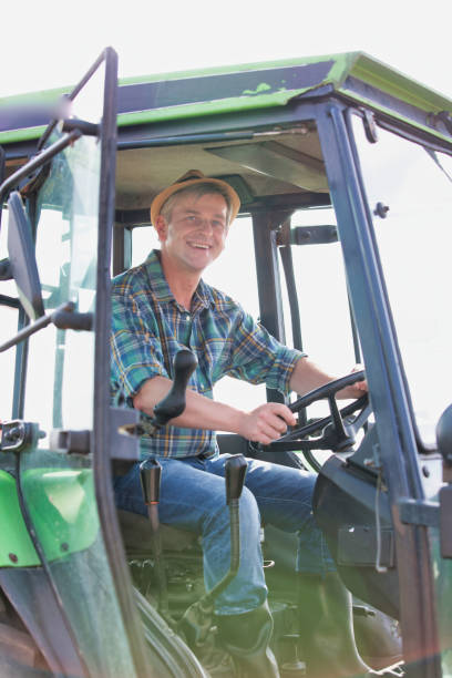 istock Mature farmer driving tractor in field 1192269652