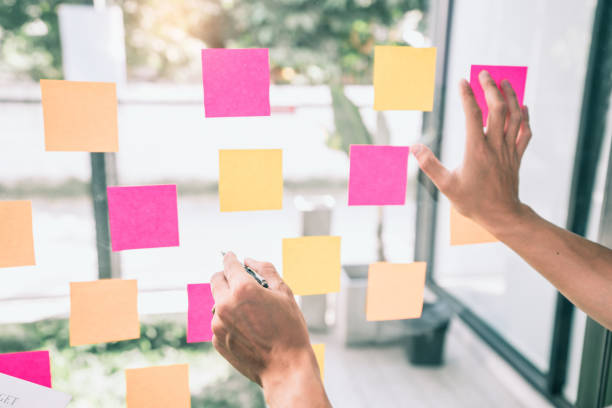 istock Cropped Hands Of Person Working By Adhesive Notes On Glass Window 1192270007