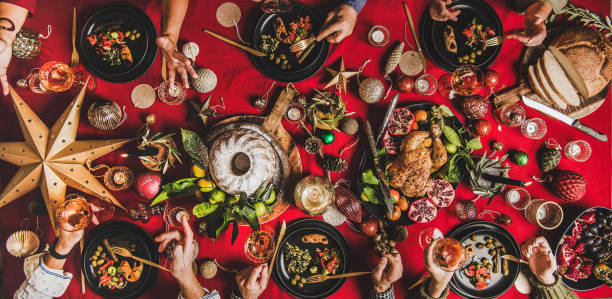 istock Friends eating and talking at festive Christmas table, wide composition 1192270285
