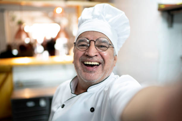 Senior chef taking a selfie in a kitchen