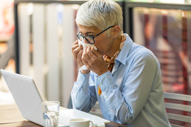 istock Older Woman with Allergic Problems is Using Paper Handkerchiefs to Blow her Nose 1192271178