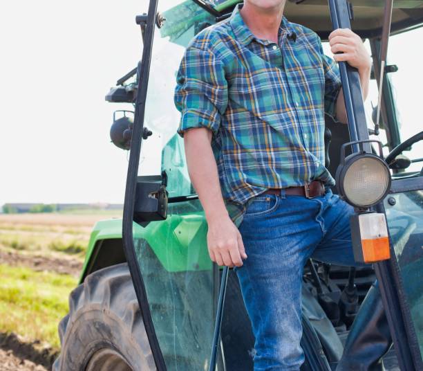 istock Mature farmer standing on tractor 1192274066