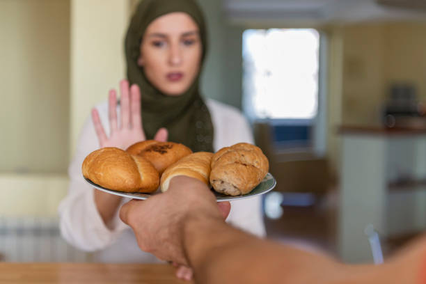 une femme musulmane refusant un aliment malsain - dieting food rejection women photos et images de collection