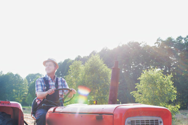 istock Mature farmer driving tractor in field 1192276314