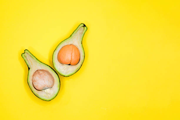istock Ripe avocado on yellow background top view. Creative food composition Flat lay. Pop art design, tropical summer abstract background with avocado. Green avocadoes pattern 1192276467