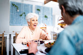 Two senior woman toasting with glass of wine in a restaurant
