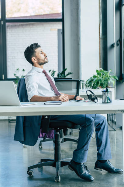 istock thoughtful call center operator looking away while sitting at workplace near laptop and headset 1192277673
