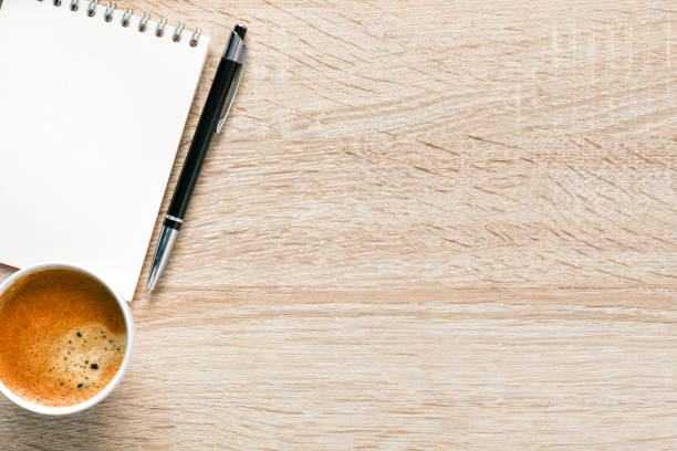istock Office desk with coffee, notepad and pen. Top veiw with copy space. 1192278931