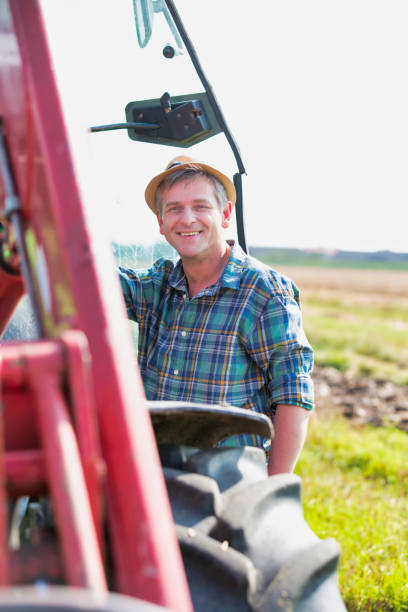 istock Farmer driving tractor in field 1192278938