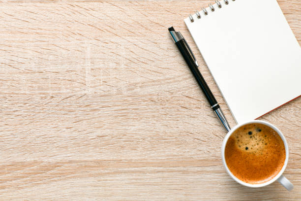 istock Office desk with coffee, notepad and pen. Top veiw with copy space. 1192279027