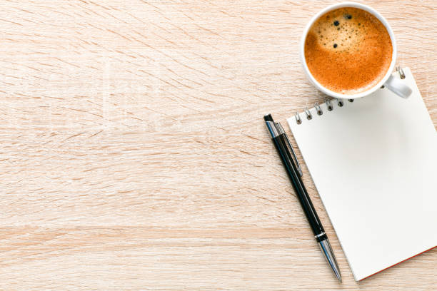 istock Office desk with coffee, notepad and pen. Top veiw with copy space. 1192279132