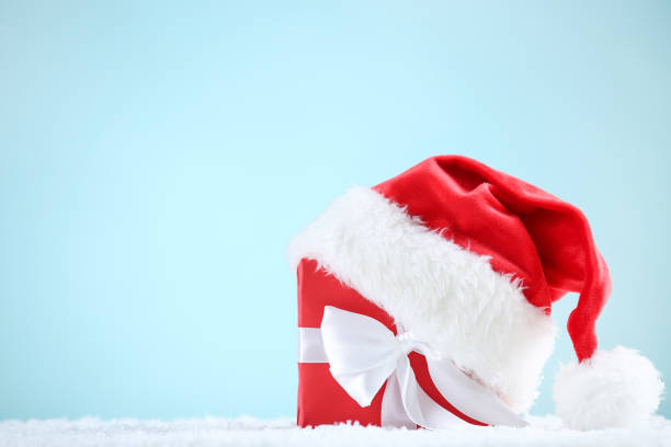 istock Red santa hat with gift box on blue background 1192280402