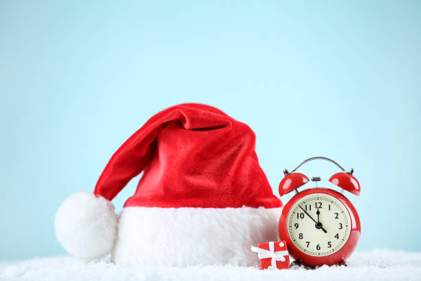 istock Santa hat with red alarm clock and gift box on blue background 1192280529