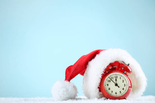 istock Santa hat with red alarm clock on blue background 1192280554