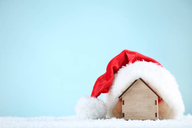istock Red santa hat with house model on blue background 1192280642