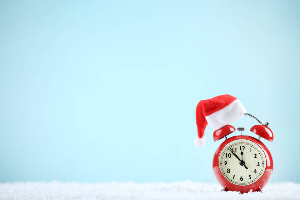 istock Red alarm clock with santa hat on blue background 1192281737