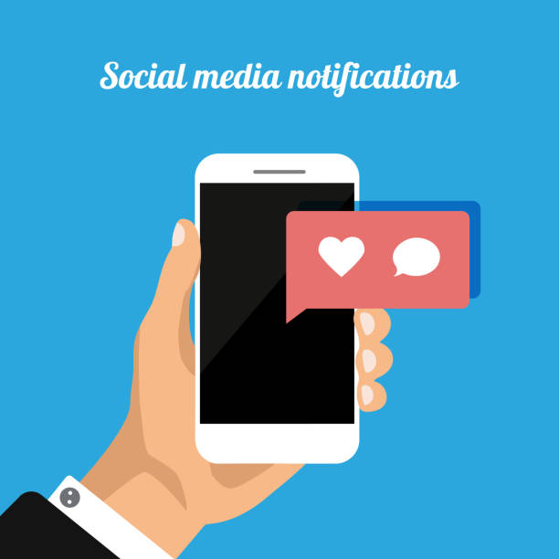 istock Hand holds smartphone with social media notifications icons: like, heart, comment. 1192282776