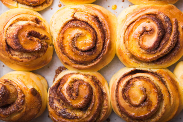 istock Fresh homemade cinnabon with cinnamon  on parchment on rustic background. top view 1192283016
