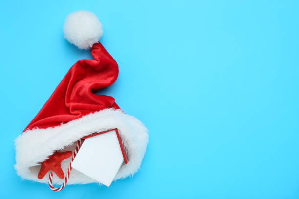 istock Red santa hat with house model, starfish and candy cane on blue background 1192283235