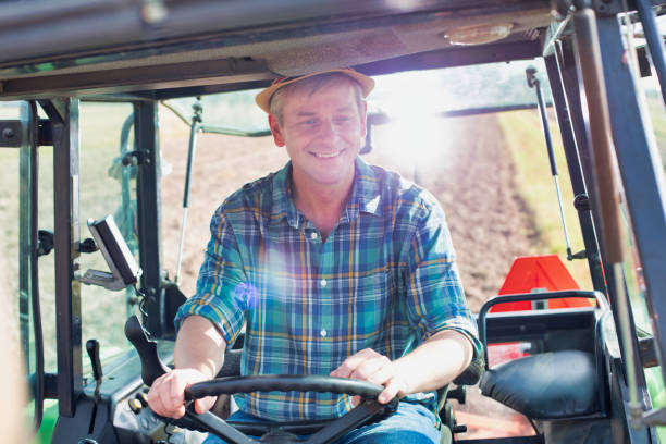 istock Mature farmer driving tractor in field 1192284007