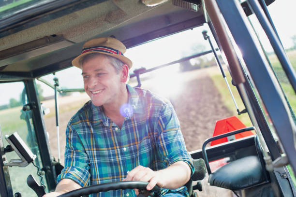 istock Mature farmer driving tractor in field 1192284210