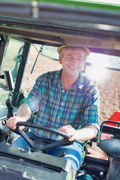 istock Mature farmer driving tractor in field 1192284236