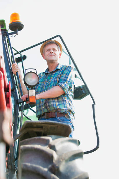 istock Mature farmer standing in combine harvester 1192285122