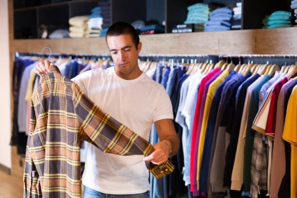 istock Man chooses fashionable checkered shirt 1192288458