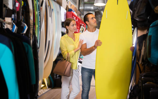 istock Couple searching surfboard at store 1192288499