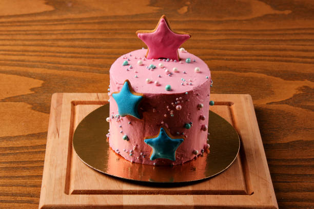 istock pink cake with asterisks on a wooden board, pastries in icing 1192288576