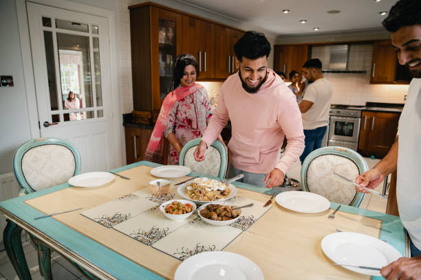 Dishing Out The Family Dinner A shot of the family working together to set the table for a family feast. indian dinner stock pictures, royalty-free photos & images