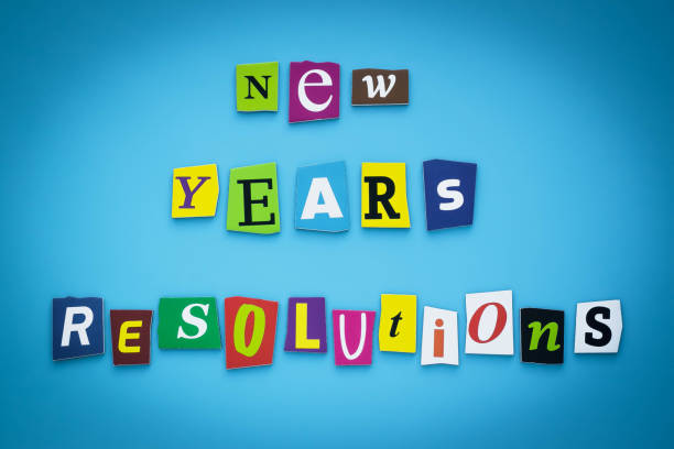 istock Text - New year's resolutions. Cut colorful letters on blue background. Writing on banner, card. Inscription, message on poster. 1192294943