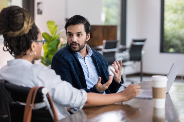 istock Mid adult male discusses workplace issues with unrecognizable woman 1192298832