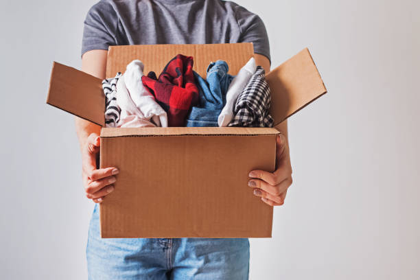 istock Unrecognizable woman holding box with clothes in it. close-up. 1192300430