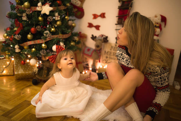 istock Mother and daughter having fun next to the New Year tree 1192303983