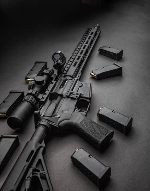 istock Modern automatic carbine with optical and collimator sight. A rifle with two sights on a dark background. Cartridges for weapons near a carbine. 1192304209