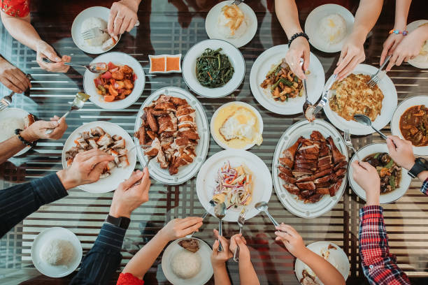 la famiglia cinese asiatica si gode il cibo fatto in casa durante la cena di riunione del capodanno cinese - riunione di famiglia foto e immagini stock