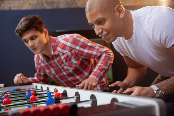 istock Male friends playing foosball 1192307917