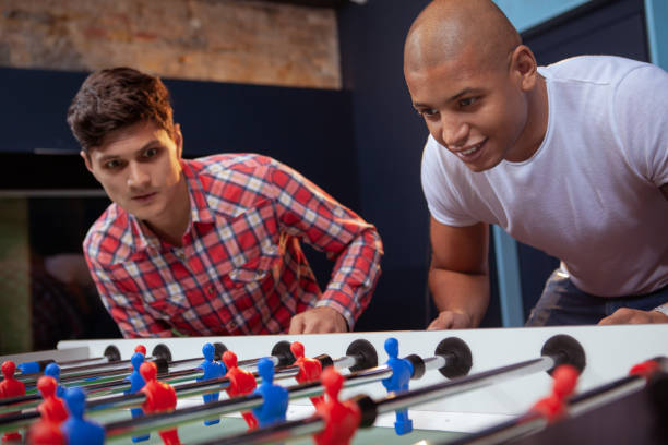 istock Male friends playing foosball 1192307929