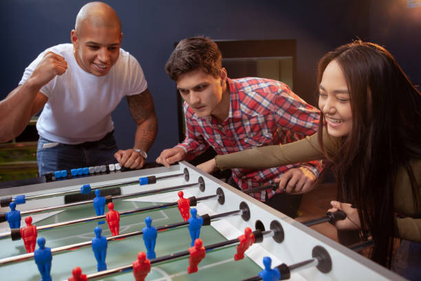 istock Diverse group of friends playing foosball 1192308129