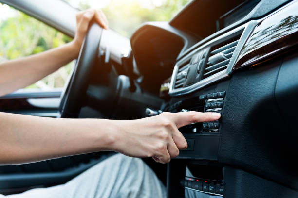kobieta siedząca w samochodzie i dotyk palca do zabawy w auto inteligentnym systemie - radio controlled zdjęcia i obrazy z banku zdjęć
