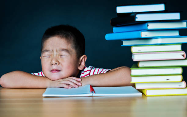 istock Tired schoolboy sleeping on desk 1192309324