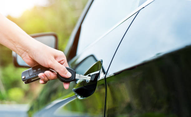 donna che inserisce la chiave nella porta dell'auto - car insurance women driving foto e immagini stock