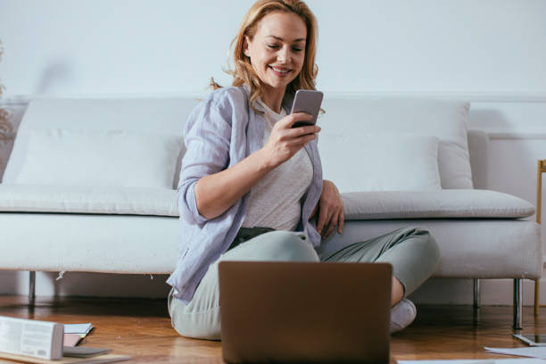 istock Smiling Woman Using Cell Phone at Home 1192311724