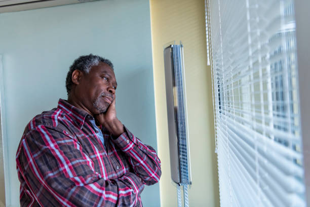 istock Afro Senior Man Looking Through The Window 1192312263
