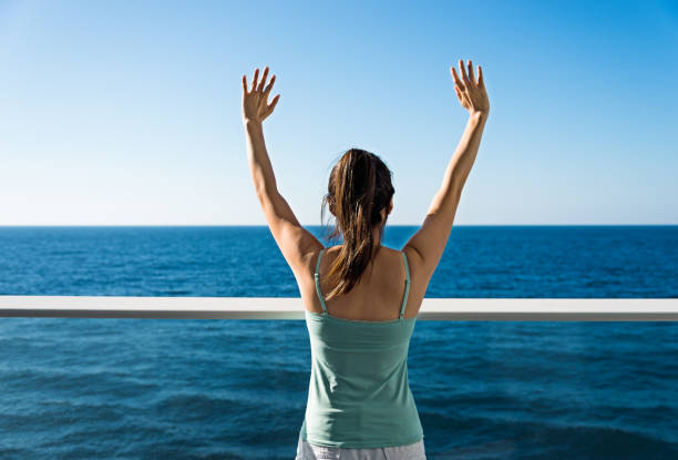 Cheering woman open arms on cruise.